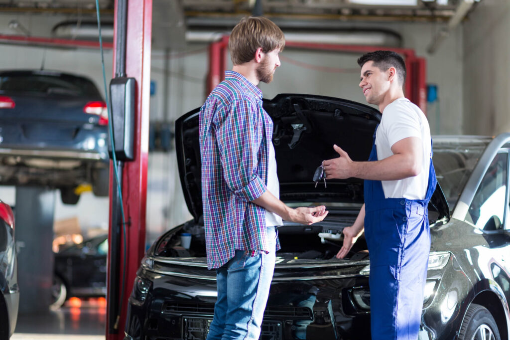 man consulting a car technician