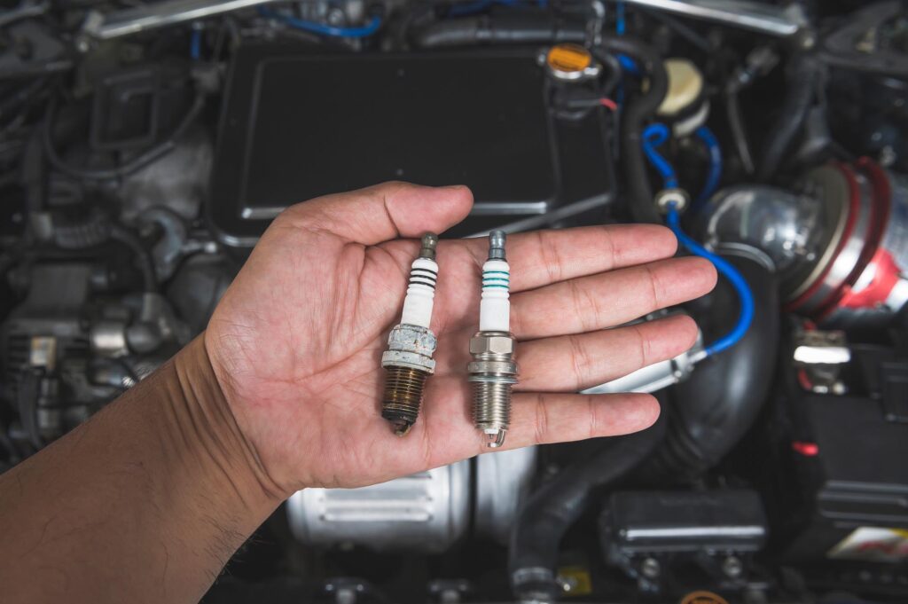old spark plugs being replaced with new one
