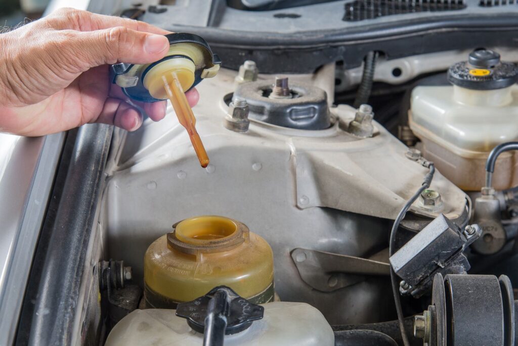 mechanic checking power steering fluid level