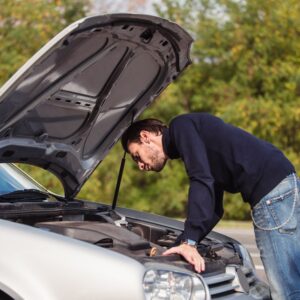 man checking the engine bay of a car