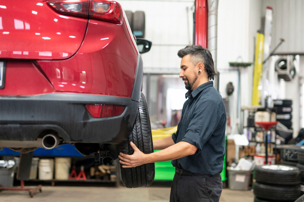 A,Nice,And,Cool,Mechanic,Changing,Car,Tire,At,Work