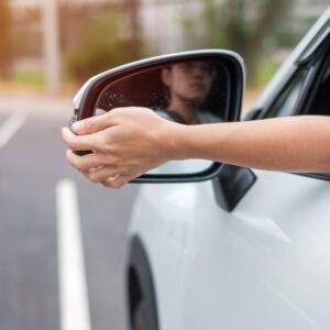 driver's hand adjusting side mirror