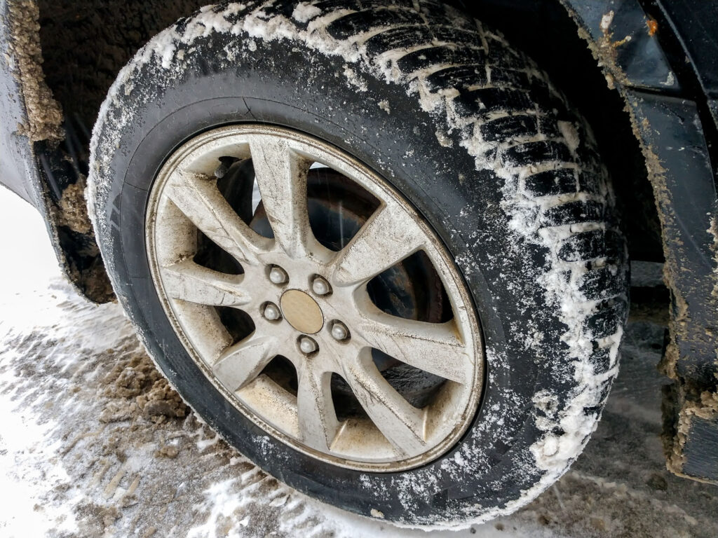 Car,Wheel,With,Snow,Stuck,To,It.,Black,Car,Is
