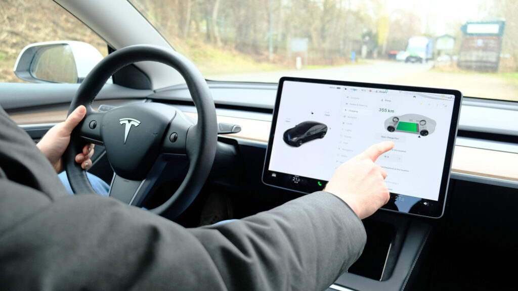 Male,Sits,Behind,Wheel,In,Car,And,Uses,Electronic,Dashboard