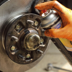brake cleaner being sprayed on brake rotor