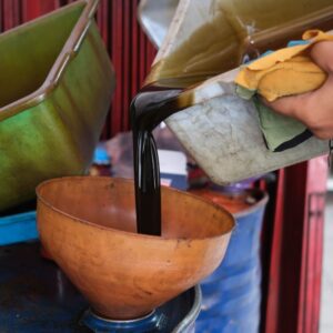 pouring used oil in a funnel