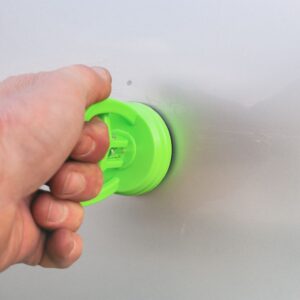 hand using a dent puller to a car
