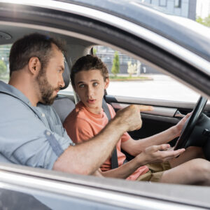 man teaching teen son how to drive