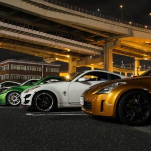 row of japanese cars parked beside a road