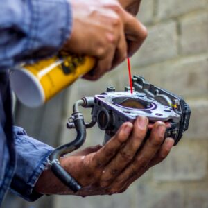 mechanic cleaning carburetor