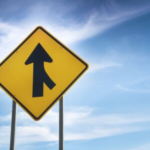 close up shot of a merging traffic road sign