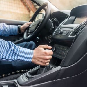 holding a manual gear stick while driving