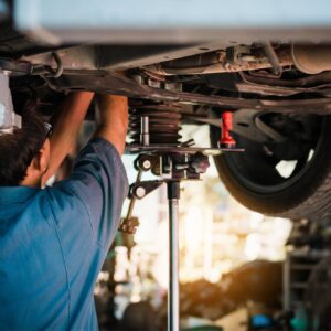 mechanic checking car chassis for lubrication