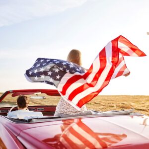 woman in a car holding a US flag