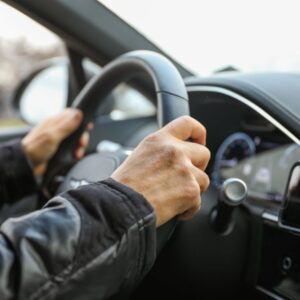 both hands holding the steering wheel