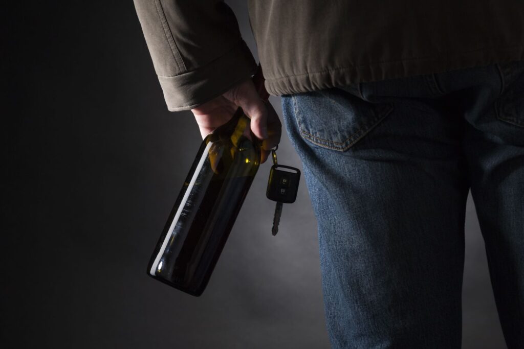 man with car keys and beer
