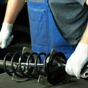 mechanic holding a replacement shock absorber