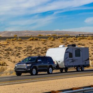 black SUV towing a trailer on a desert