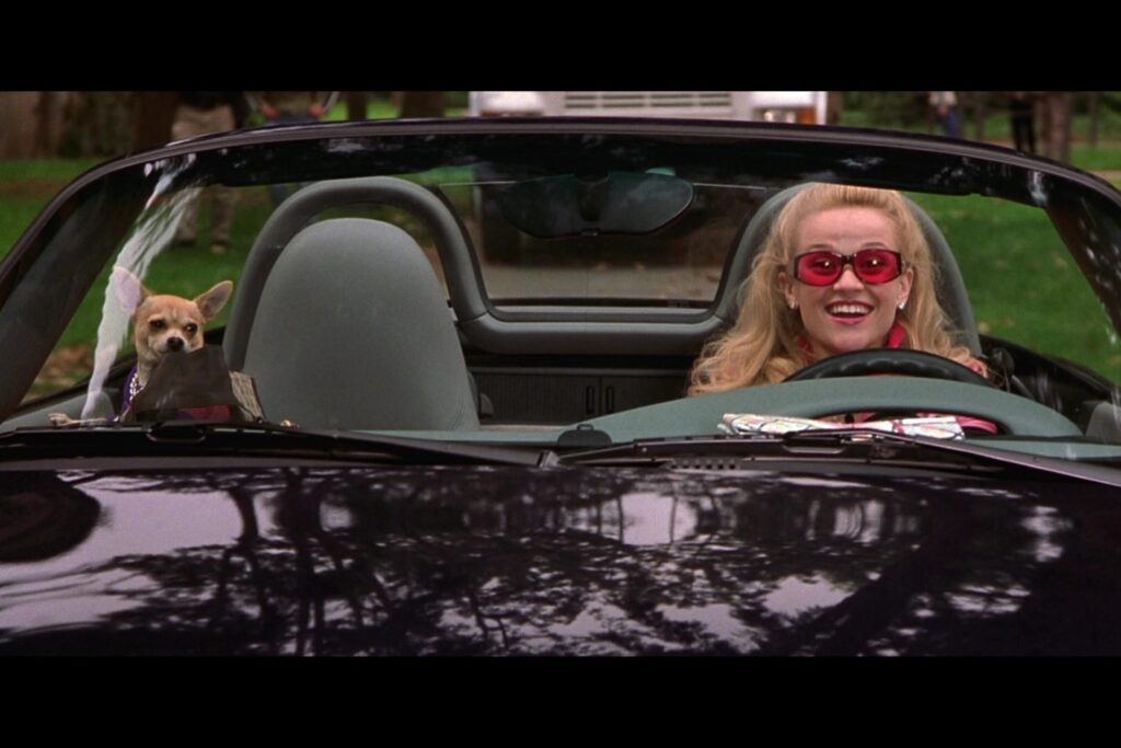 elle woods and moonie in a convertible car