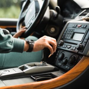 driver holding the steering wheel and gear stick