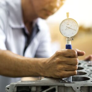 mechanic using a dial bore gauge