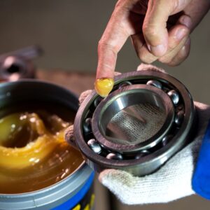 mechanic greasing a car bearing