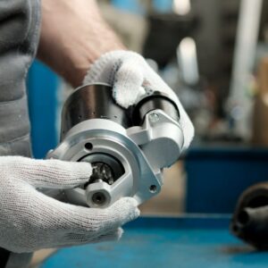 mechanic holding a car starter