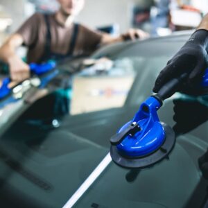 mechanics replacing a windshield