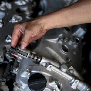 hand holding a variable valve timing solenoid