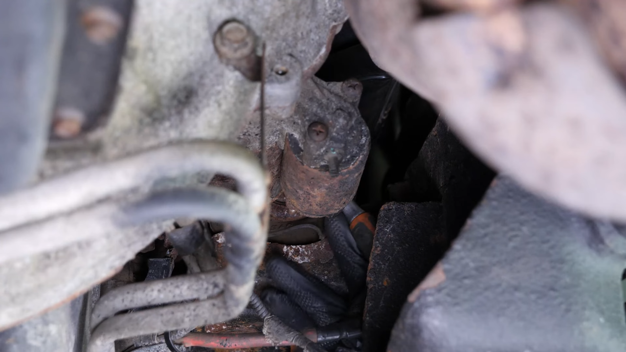Remove the bolts holding the starter