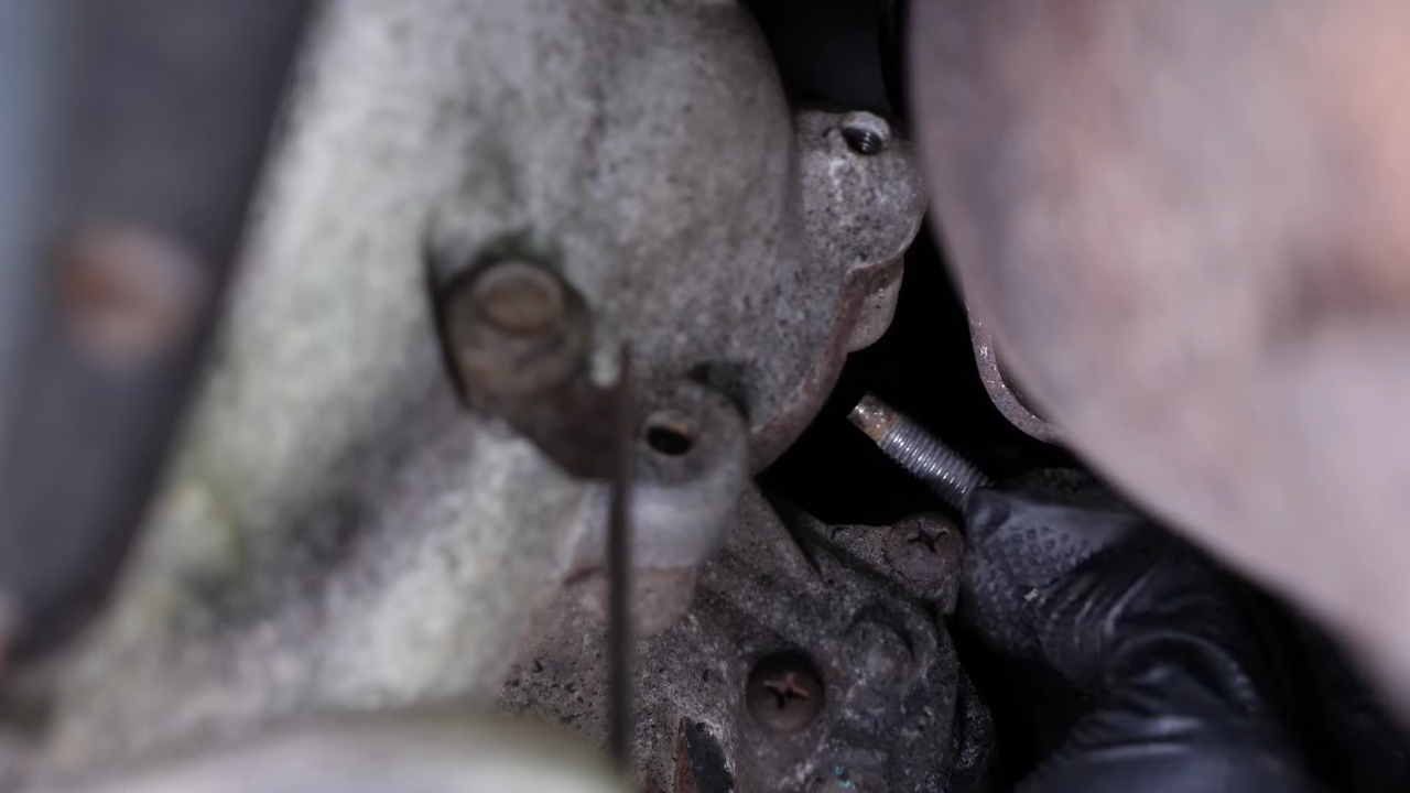 Remove the bolts holding the starter