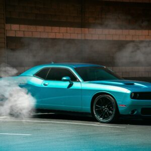 blue muscle car with smoke coming out from the tires