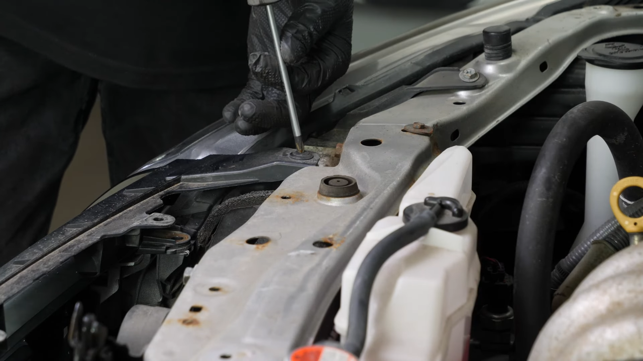 Unscrew the screw from the engine compartment
