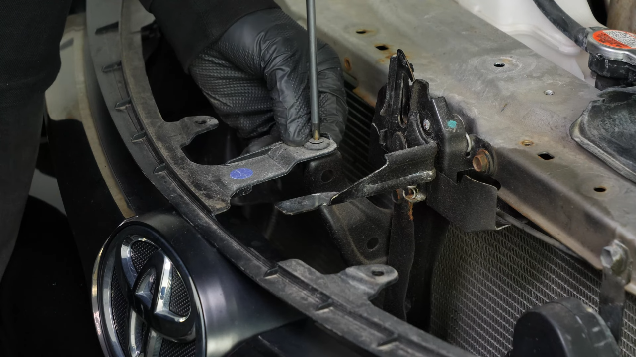 Unscrew the screw from the engine compartment