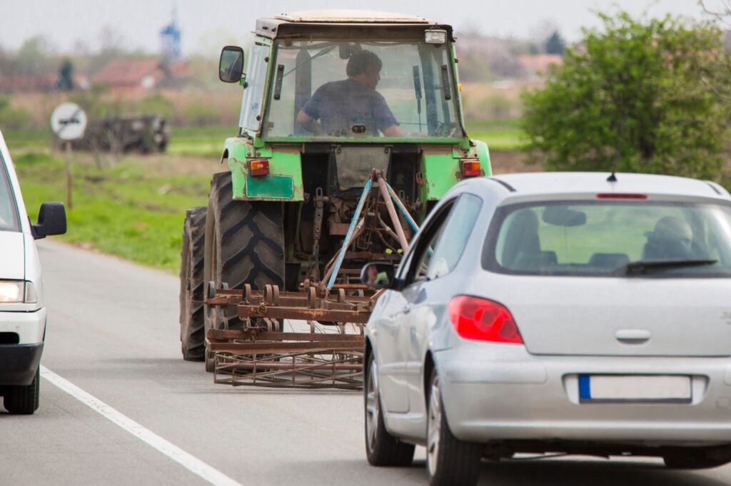 car driving near farm tractor