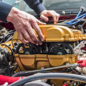 person putting a yellow engine cover to a car engine