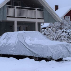 car with a cover during a snowstorm