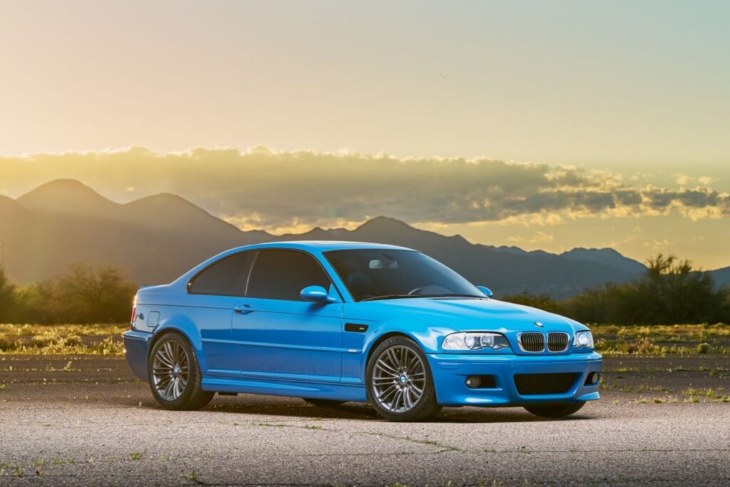 blue BMW 3 E46 with mountains in the background