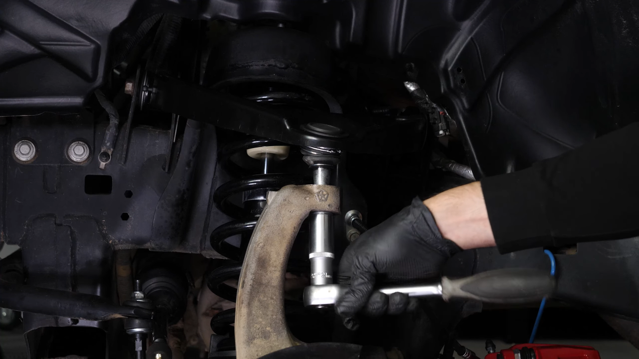 Disconnect the control arms from the wheel knuckle