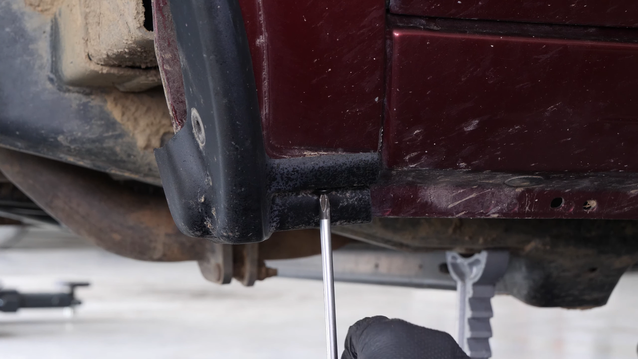 Unscrew the mud flap / fender screw