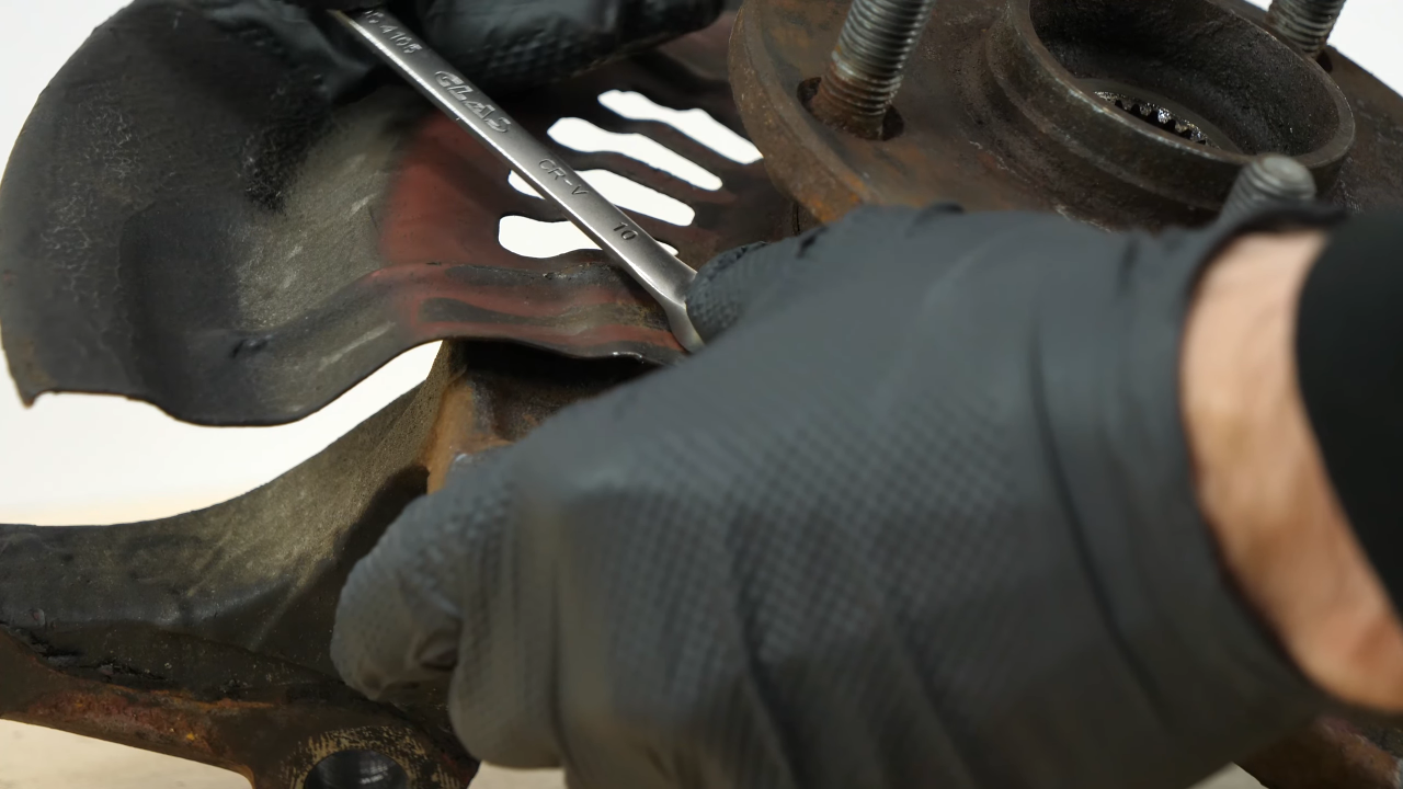 Remove the brake backing plate bolts