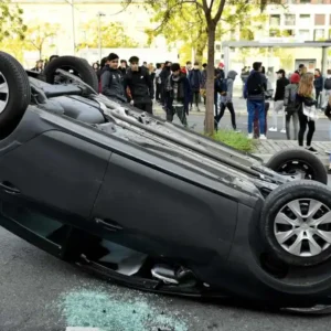a flipped car on a city street
