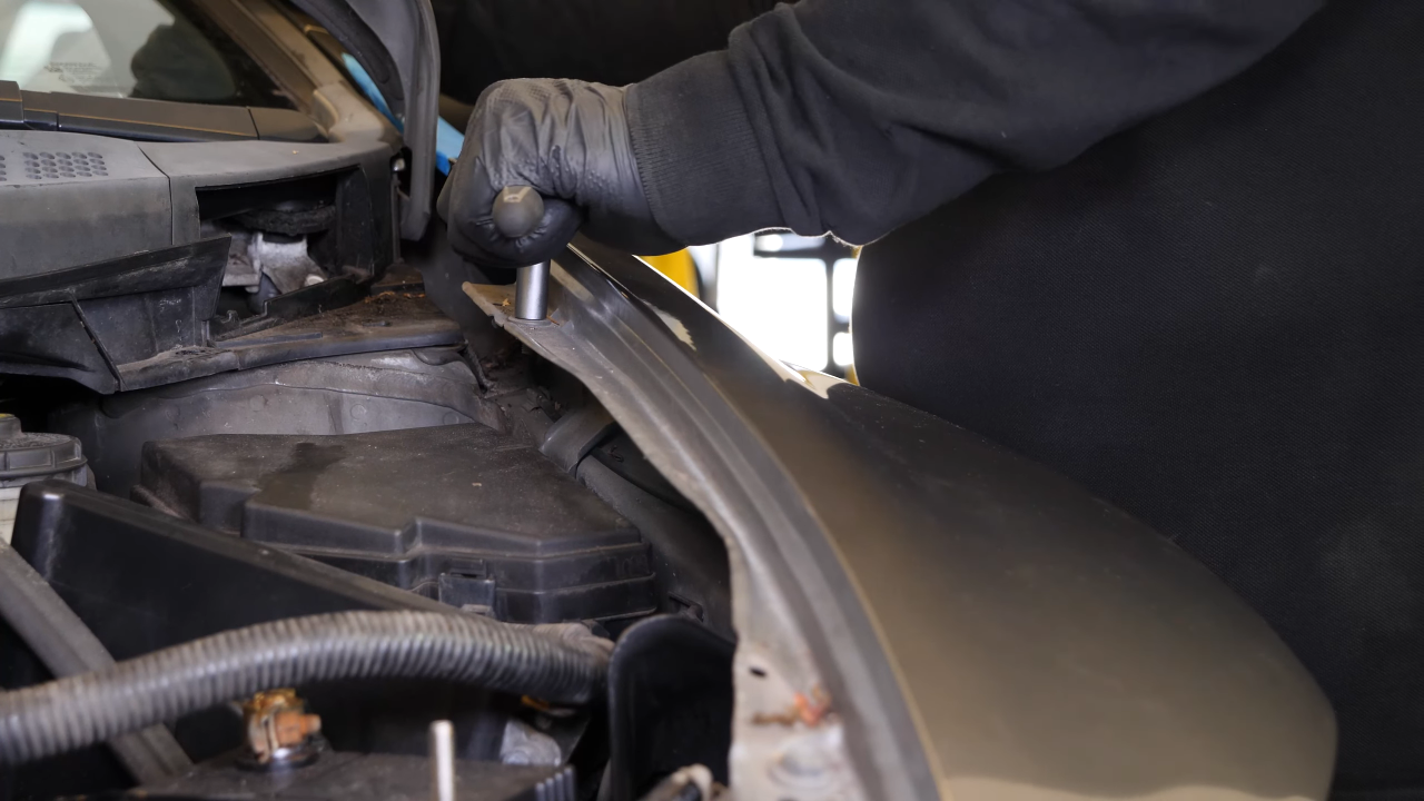Remove the bolts along the hood