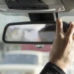 guy adjusting car mirror