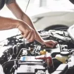 man tuning up his car