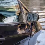 man pulling out his car out of the flood