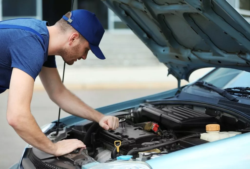 Mechanic inspecting a car's underhood parts