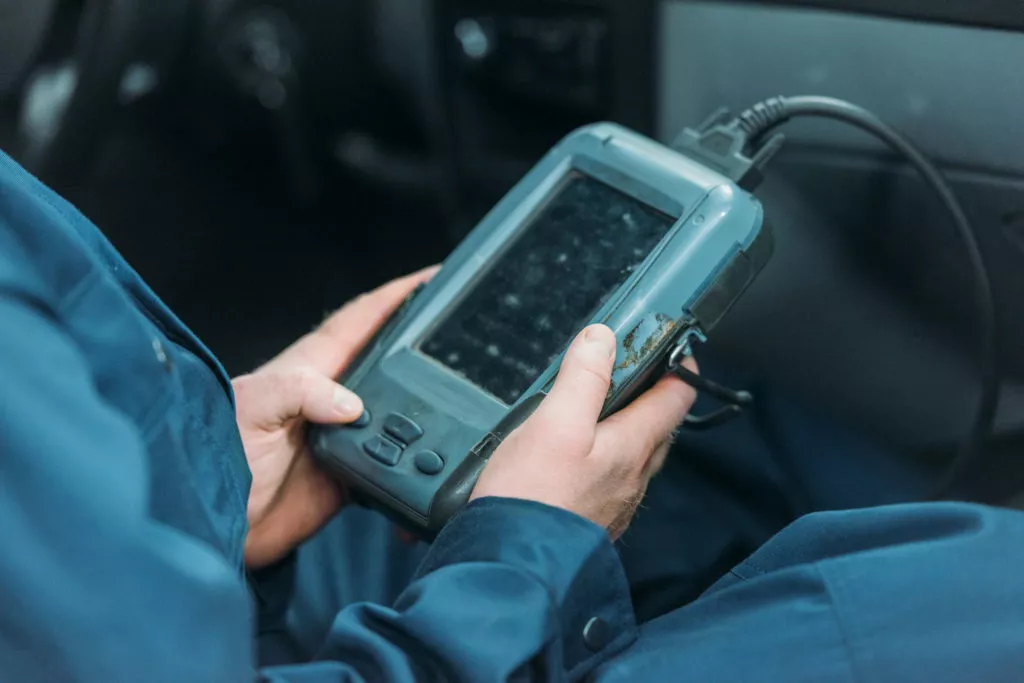 mechanic using an obd scanner to diagnose a car