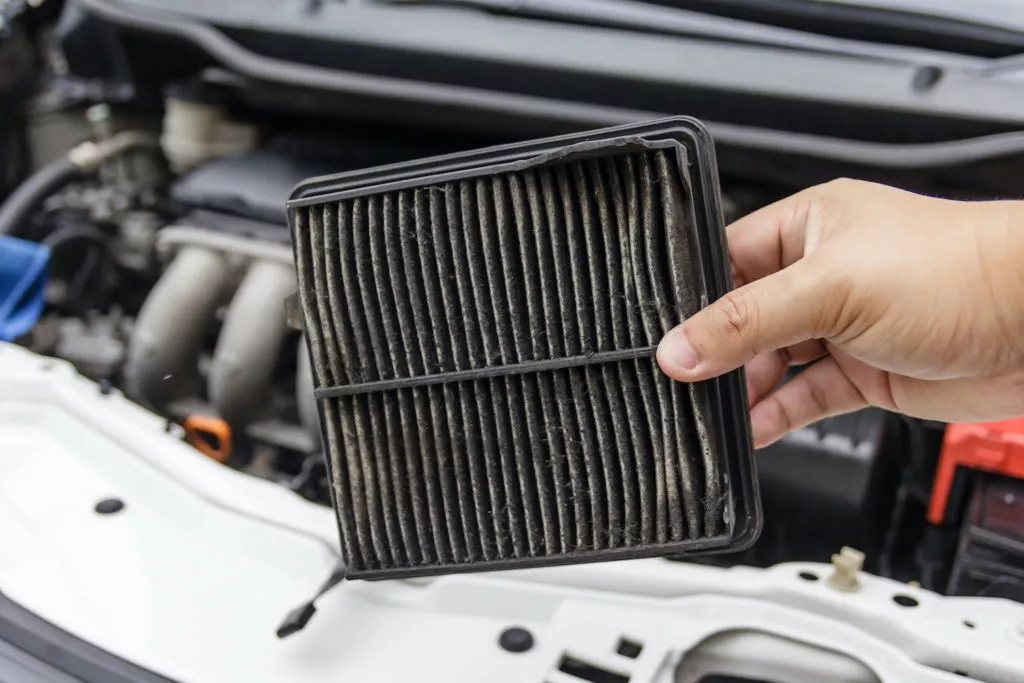 mechanic holding a dirty air filter