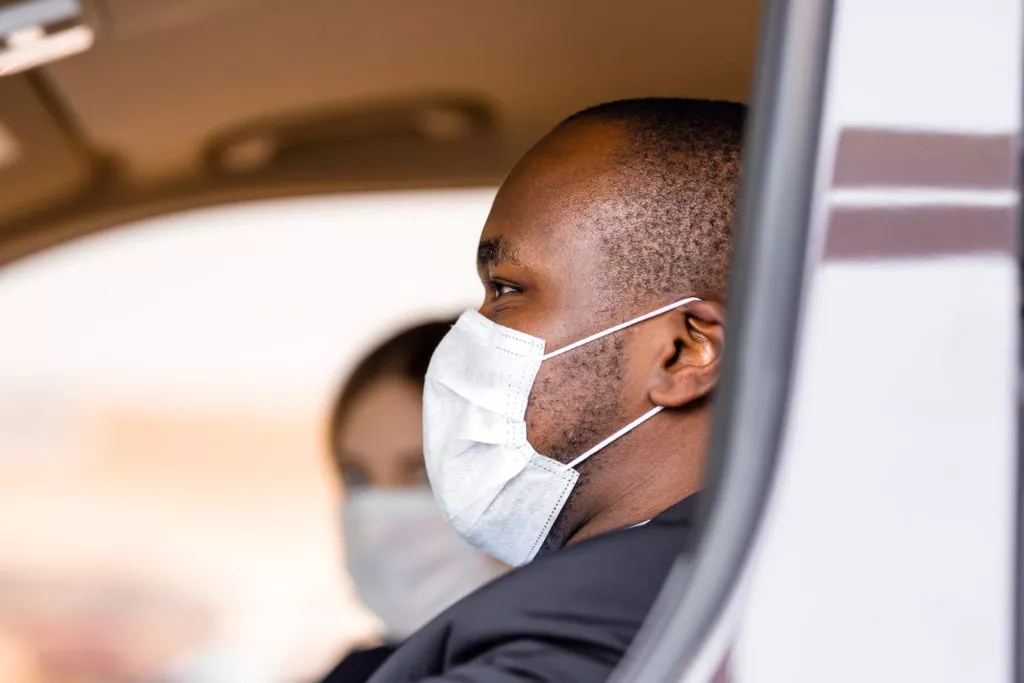couple driving while wearing masks